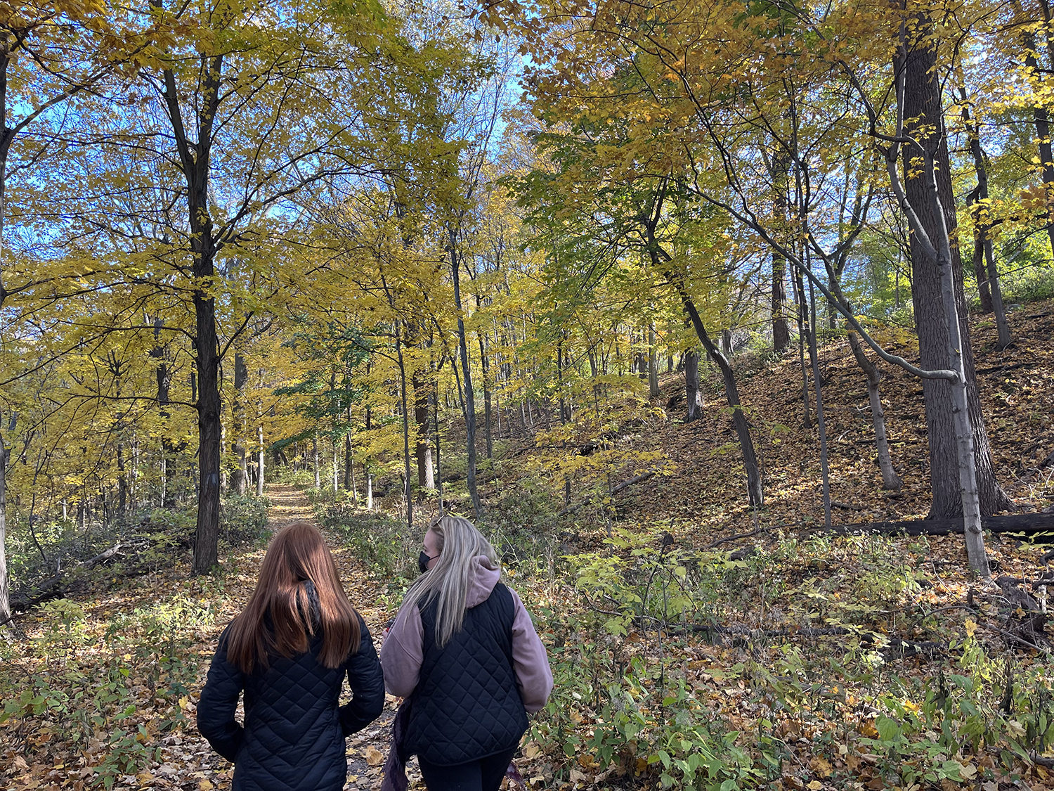 Two Brock students walking on the Bruce trail behind Brock