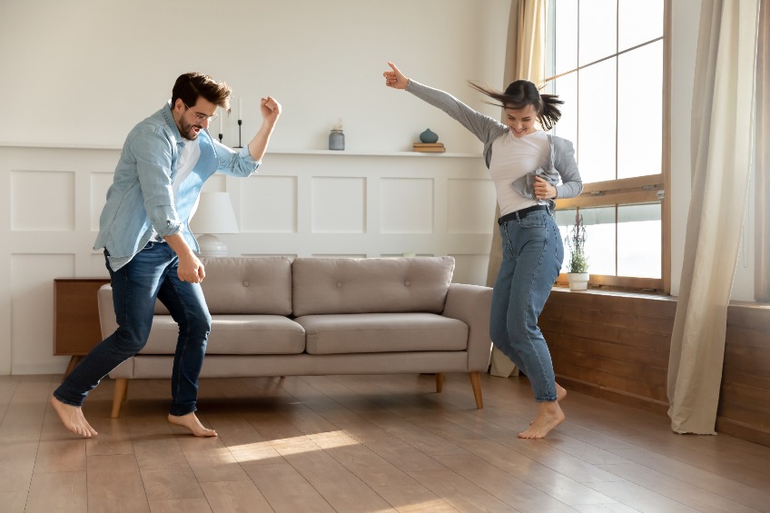 Two young people dancing in their living room